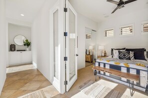 Un dormitorio con cama, mesitas de noche, un espejo y un armario.