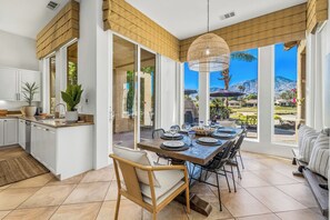 Una cocina amplia con una isla grande, un comedor con vista a las montañas y un rincón de descanso con vistas al exterior.