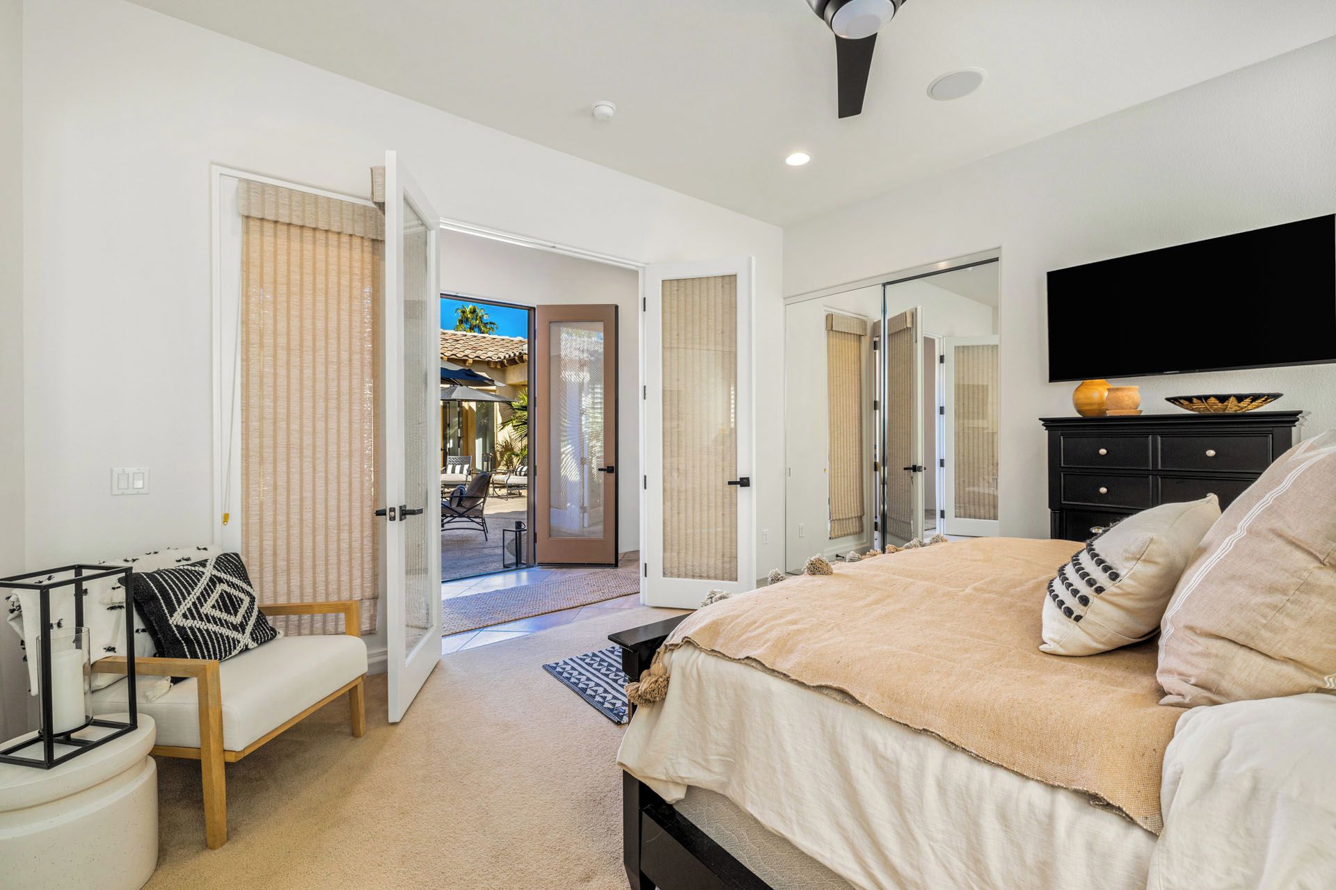A bedroom with a bed, a TV, a dresser, and a chair.