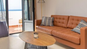 A modern living room with a leather sofa, a round coffee table, and a floor lamp. - Vacation home Melon by Interhome (La Herradura)