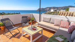 A terrace with a sofa, a chair, a table, and potted plants. - Vacation home Melon by Interhome (La Herradura)
