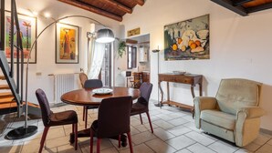 A dining area with a round table, chairs, and artwork on the walls.