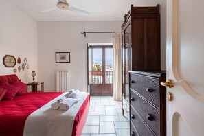 A bedroom with a bed, a dresser, a radiator, and a view of the outside. - Domus Sicile - Panormus Cala a Mare (Palermo)