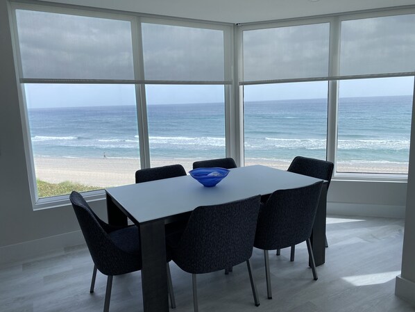 Ein Zimmer mit großem Fenster mit Blick auf Strand und Meer.