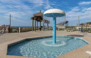 Une piscine avec une fontaine, un belvédère et une vue sur la plage.