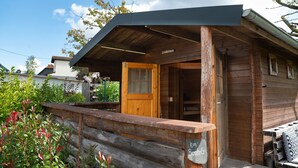 A wooden cabin with a porch, a door, and a sign that reads 'Königshof.' - Holiday Home 'Traumzeit' with Private Terrace, Private Garden and Wi-Fi (Neuhütten)