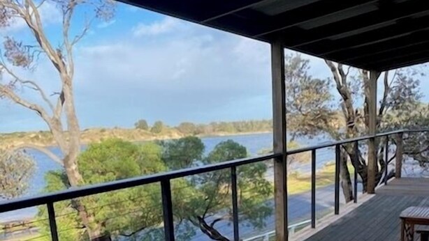 A wooden deck with a glass balustrade overlooking a body of water and trees. - Perfect Waterfront Escape in Marlo | Balcony Views & Nature All Around (Marlo)
