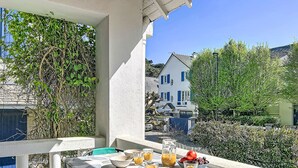 Ein Balkon mit einem Frühstückstisch, ausgestattet mit Schüsseln, Gläsern und Obst.
