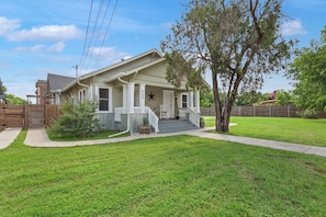 A single-story house with a front porch, a mailbox, and a number '908' on the wall.
