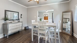 A dining area with a white table and chairs, a ceiling fan, and a wooden floor. - Downtown Gem near Silos, Baylor, Cameron Park... (Waco)