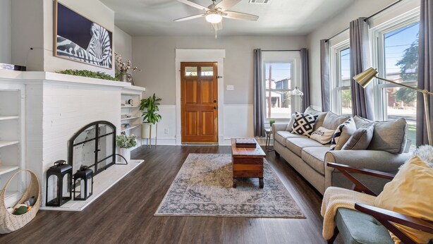 A living room with a fireplace, a sofa, a coffee table, and a ceiling fan. - Downtown Gem near Silos, Baylor, Cameron Park... (Waco)