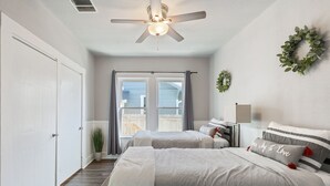 A bedroom with a bed, a ceiling fan, a window with curtains, and a door. - Downtown Gem near Silos, Baylor, Cameron Park... (Waco)