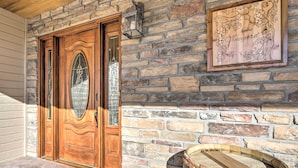 Eine Holztür mit Glasfenster, eine Steinmauer und ein gerahmtes Schild mit der Aufschrift 'The Vineyard'.