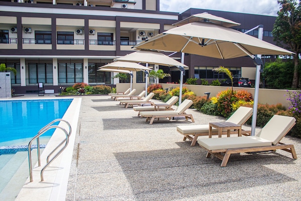 Una piscina al aire libre, tumbonas