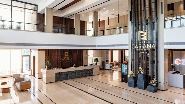 A modern hotel lobby with a reception desk, seating area, and a large vertical sign for the Casiana Hotel & Events Center. - Hotel Casiana and Events Center Tagaytay (Tagaytay)