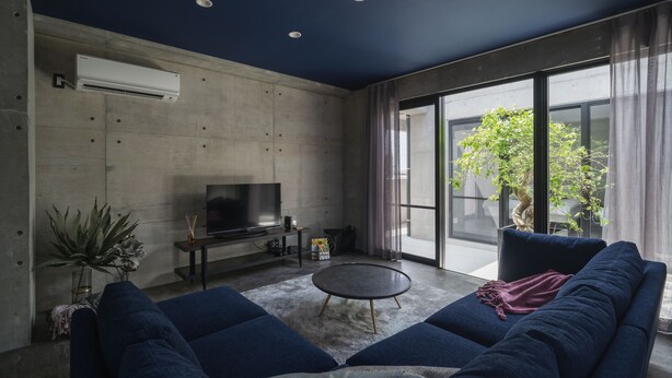 Un salon moderne avec un canapé, une table basse et un téléviseur à écran plat posé sur un meuble.