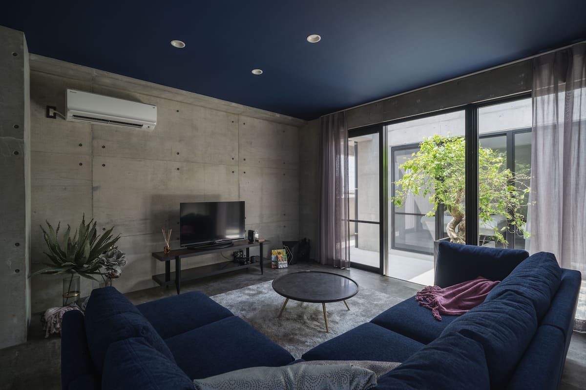Una sala de estar moderna con un sofá, una mesa de centro y un televisor de pantalla plana sobre un mueble.