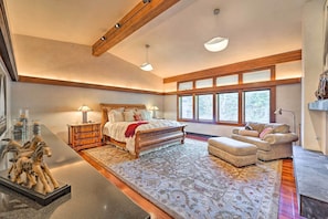 Un dormitorio espacioso con una cama grande, una zona de estar y una chimenea.