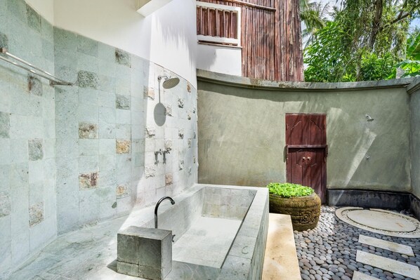 Un baño moderno con una bañera independiente, zona de ducha y un rincón de descanso circular.
