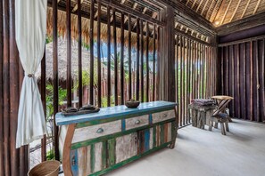 Une pièce comprenant un banc en bois, une table avec un bol et une chaise.