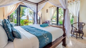 Ein Schlafzimmer mit Bett, Baldachin und Blick ins Freie.