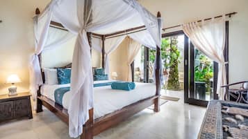 Una cama con dosel y cuatro columnas, con vistas al jardín a través del ventanal.