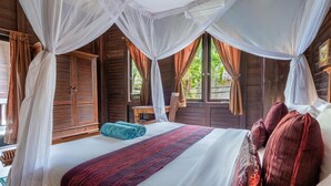 A bedroom with a bed, curtains, and a window. - Double Room with Alley View | The Village of Angels Resort | Candidasa (Kabupaten Karangasem)