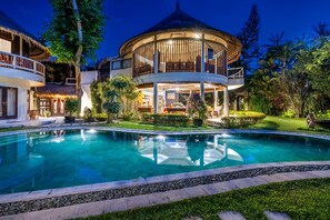 A resort with a large swimming pool, a covered outdoor area, and lush greenery. - Beachfront Group Property – 9 Separate Rooms, 3 Levels | The Village of Angels (Kabupaten Karangasem)