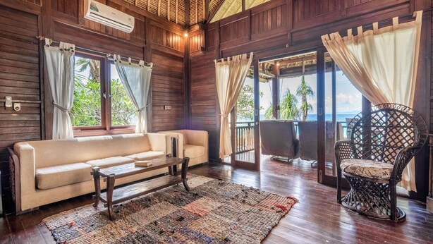 Una habitación con suelo de madera, un sofá, una mesita de centro y una alfombra estampada.
