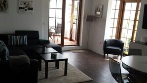 Un salon comprenant un canapé, une table basse et un coin repas avec une table et des chaises.