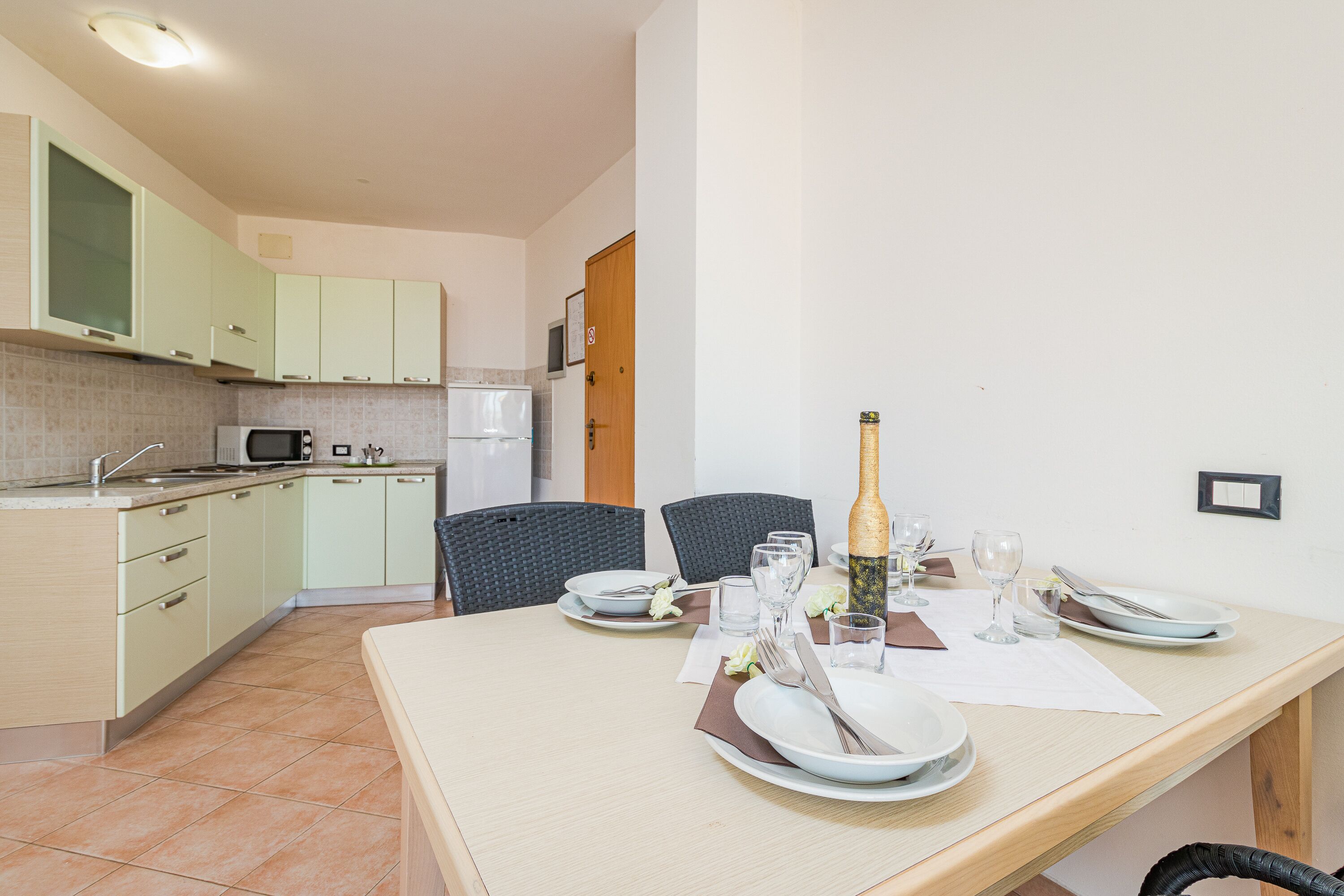 A dining area with a table set for four, including plates, glasses, and cutlery.