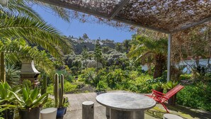 A patio with a round table and chairs, surrounded by potted plants and cacti. - Finca El Dragonal with Mountain View, Garden & Wi-Fi (Las Meleguinas, Santa Brígida)