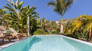 A swimming pool with lounge chairs and tropical plants. - Finca El Dragonal with Mountain View, Garden & Wi-Fi (Las Meleguinas, Santa Brígida)