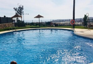 A swimming pool with a clear view of the surrounding landscape, including a construction crane and a lifebuoy.