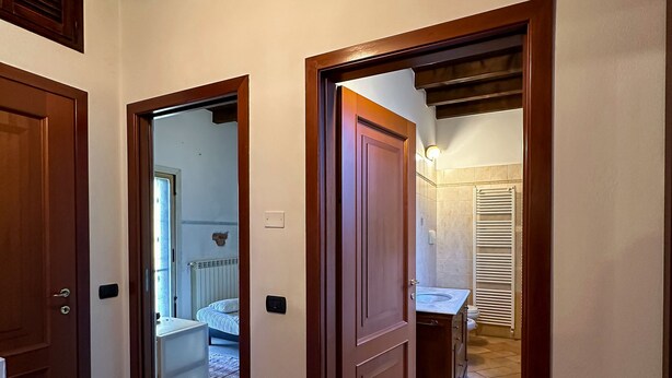 A hallway with wooden doors leading to a bedroom and a bathroom. - Appartamento in storica Cascina Lombarda Cusago (Cascina Cusago di Sotto)