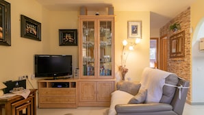 Un salon avec un téléviseur, un meuble en bois et un canapé.