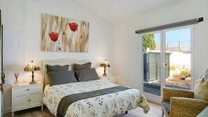 A bedroom with a bed, nightstands, lamps, a window, and a door. - Vacation home 'Los Cipreses' with Mountain Views, Indoor Pool, Garden & Wi-Fi (Ingenio)