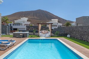 A swimming pool with a hot tub, lounge chairs, and a pergola with cushions. - Villa Los Alisios 58 with Mountain Views, Pool, Wi-Fi, Terraces and Garden (Playa Blanca)