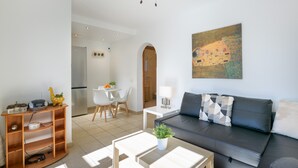 Una sala de estar moderna con sofá, una mesa de centro y un comedor con sillas y una mesa.