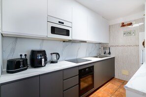 A modern kitchen with a built-in oven, a coffee maker, and a toaster.
