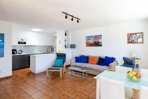 A modern apartment with a kitchen, living area, and dining space.