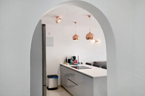 A modern kitchen with a white countertop, a sink, and two pendant lights.