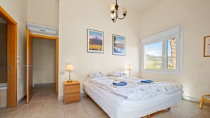 A bedroom with a bed, bedside tables, a window, and a door leading to another room. - Panoramic Sea View Villa with Large Terrace, Shared Pools & Space for 8 (Almunecar)