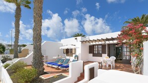 A rooftop terrace with lounge chairs, a table, and a small garden area. - Apartment "Puerto Chico 7" with Sea View, Shared Pool, Terrace & Wi-Fi (Playa Blanca)