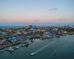 Stunning city views of a bustling marina with boats docked and a Ferris wheel in the distance.