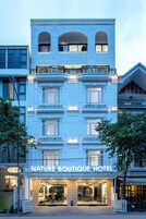 Um hotel com fachada clássica, várias varandas e entrada bem iluminada.