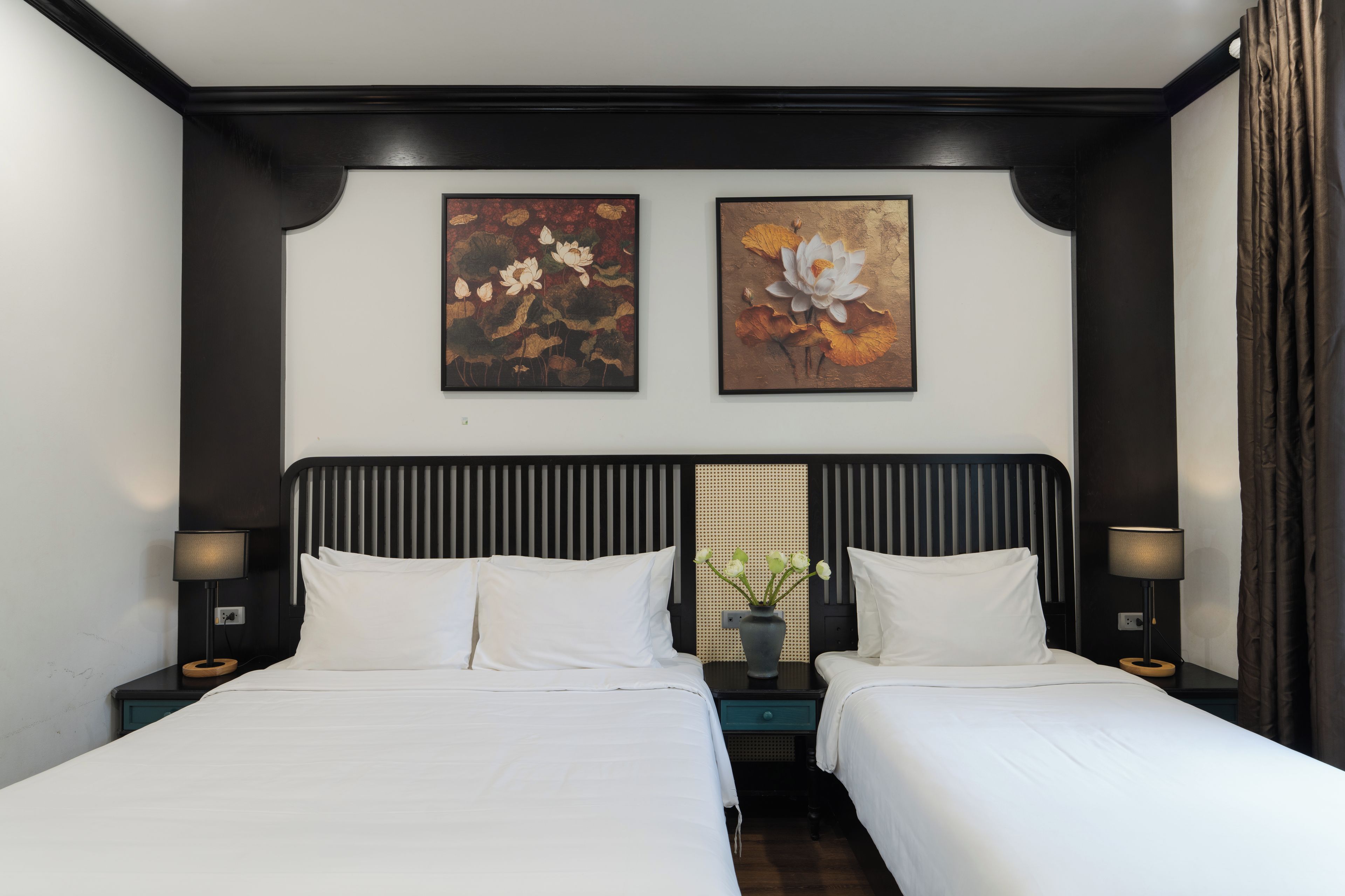 A double bed room with two bedside tables, a nightstand, and two wall-mounted lamps.