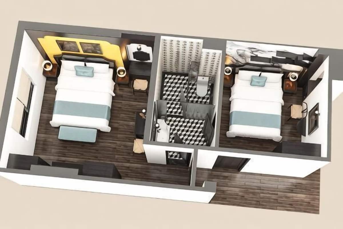A hotel room layout with two beds, a desk, a chair, and a small bathroom area.