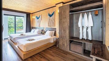 Un dormitorio moderno con dos camas, suelo de madera, un armario grande y vistas a zonas verdes.