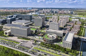 Un área urbana moderna con rascacielos, una estructura circular y un río.